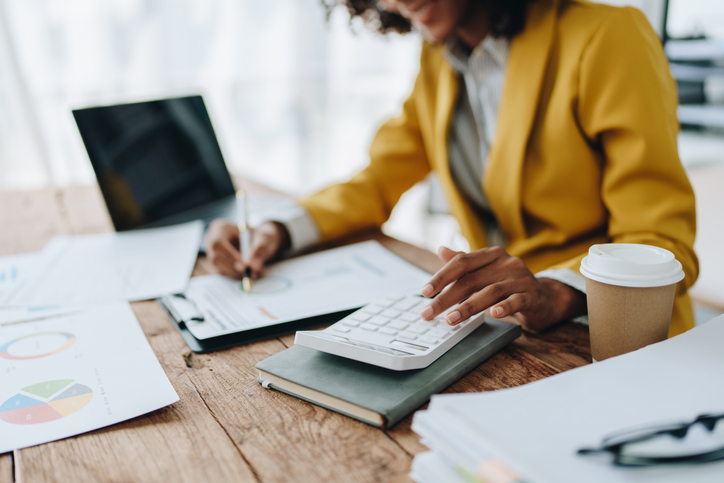 Female bookkeeper working on financial papers in an office after completing her bookkeeper training