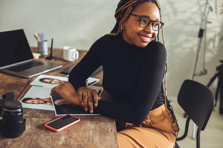 A smiling grad from a career training program sitting at a desk.