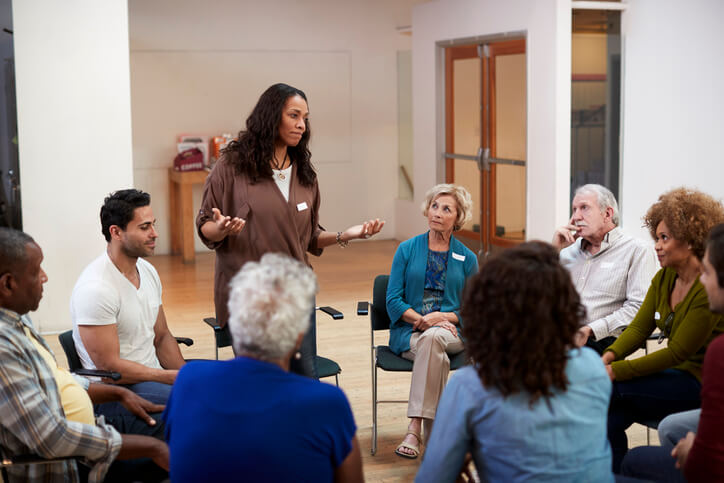 A community service worker in BC leading a support group meeting in a local community center after completing her community service worker program.