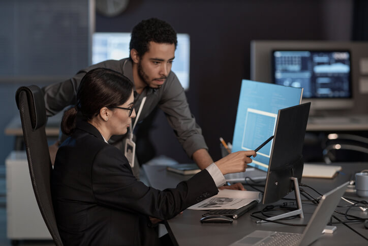 An IT support specialist helping a colleague with their desktop